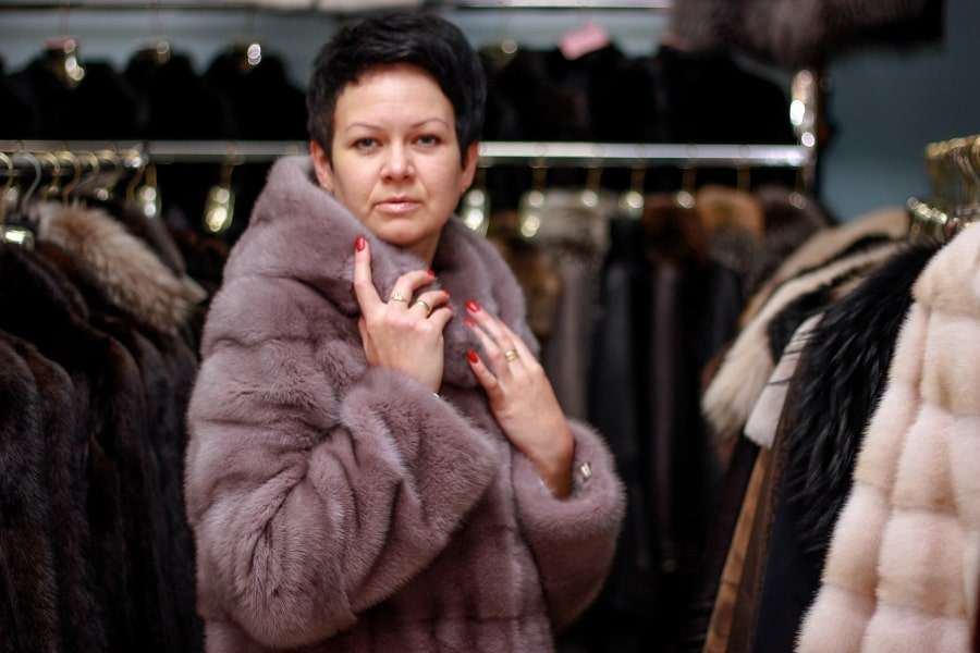 Женщина примеряет шубу